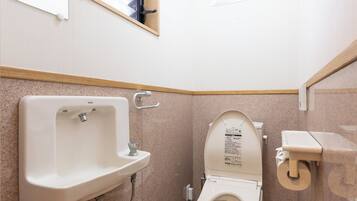 A small, clean bathroom with a toilet, sink, and window.