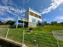 A modern two-story building with a balcony on the upper floor.