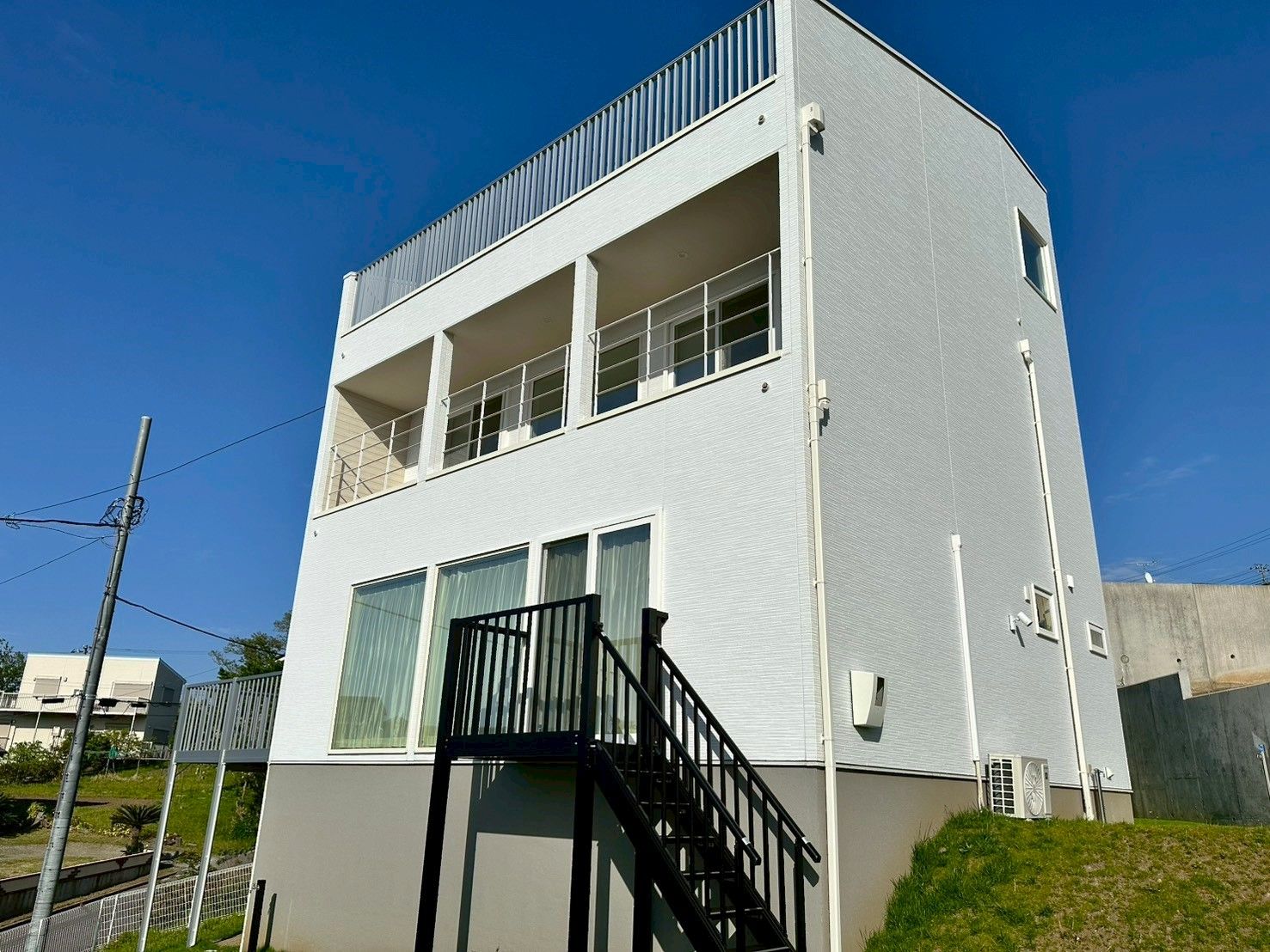 Un bâtiment à deux étages doté d’un balcon à l’étage supérieur et d’un escalier menant à l’entrée.