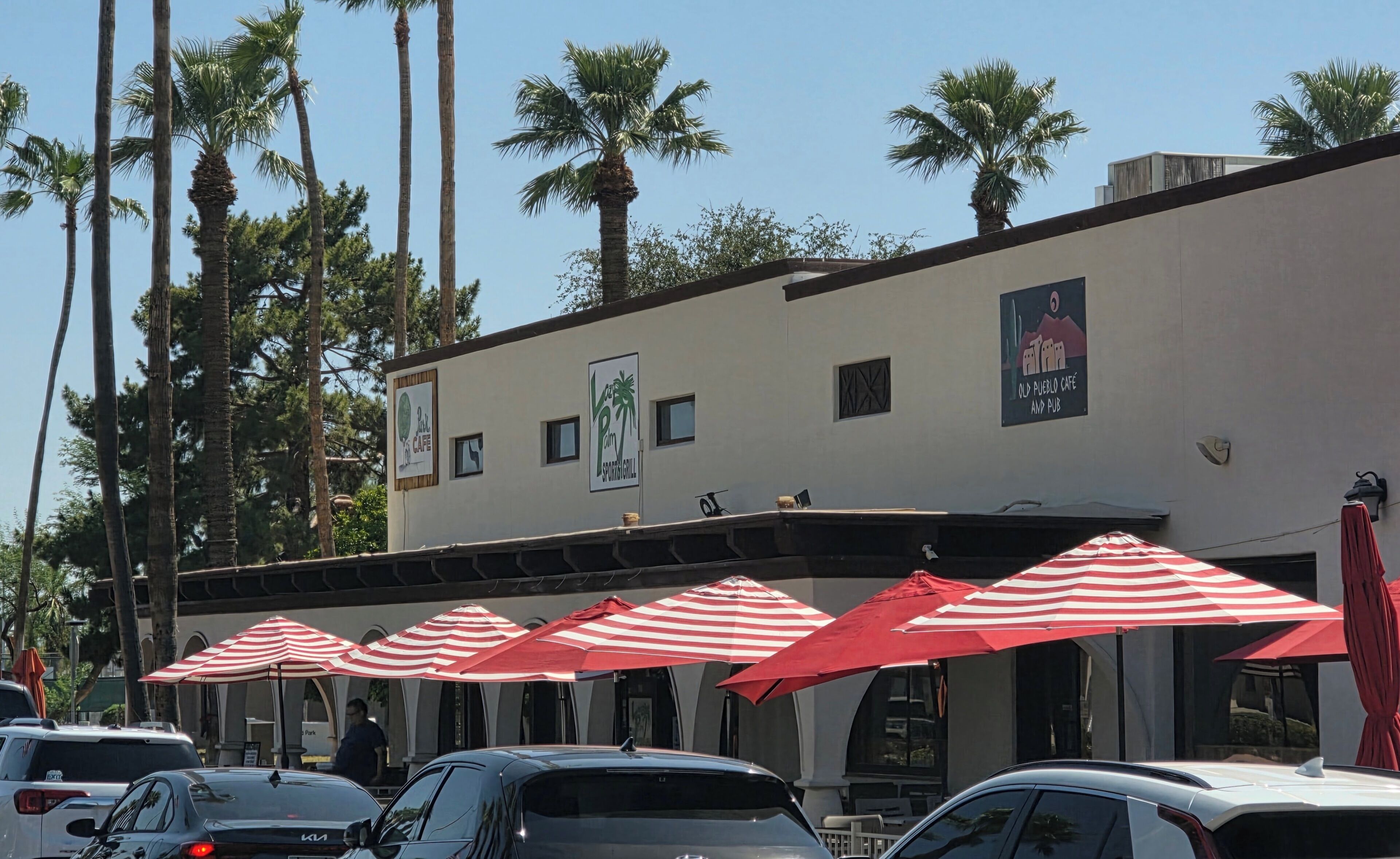 A building with a sign for 'Palm Cafe' and 'Old Pueblo Cafe & Pub.'