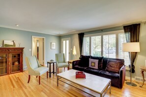 Ein Wohnzimmer mit Holzboden, einer Couch, einem Couchtisch und einem Schrank mit Glastüren.