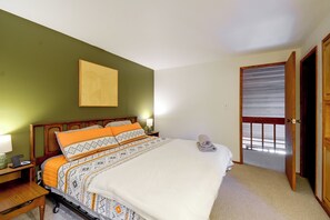 A bedroom with a bed, a nightstand, a lamp, and a door leading to a balcony. - Hood Canal Views & Near Alderbrook Resort! (Union)