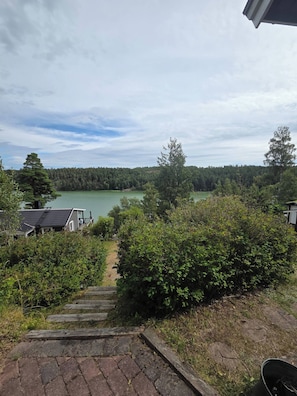 Un quartier résidentiel avec vue sur un lac, un escalier en bois menant à une maison et un ciel dégagé.