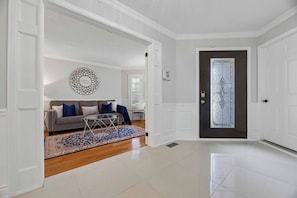 A living room with a sofa, a coffee table, and a decorative mirror.