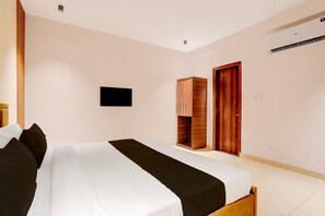 A hotel room with a bed, a wardrobe, a television, and an air conditioning unit. - Super Deluxe Room Subhash Nagar Metro Station (New Delhi)