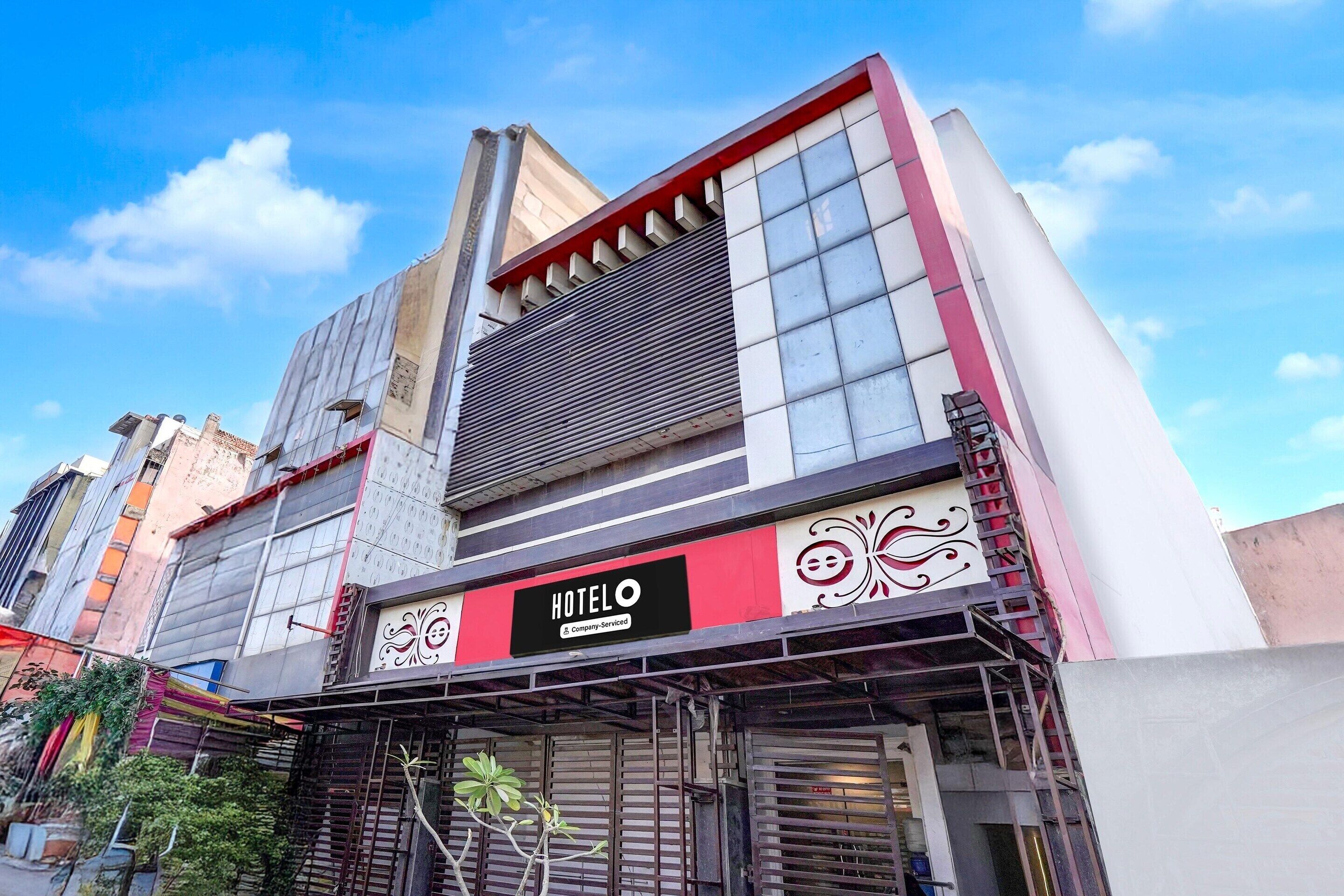 A hotel with a prominent sign, a modern facade, and a clear sky.