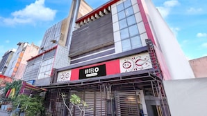 Um hotel com uma placa visível, fachada moderna e céu claro.