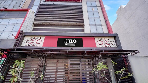 Um hotel com uma fachada vermelha e branca e portões de metal.