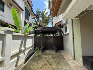 A courtyard with a wooden fence, a bench, and a small garden area with plants. - The Oasis - Modern Villa with Private Pool, Gym, Pond & Chef’s Kitchen (Bandar Baru Bangi)