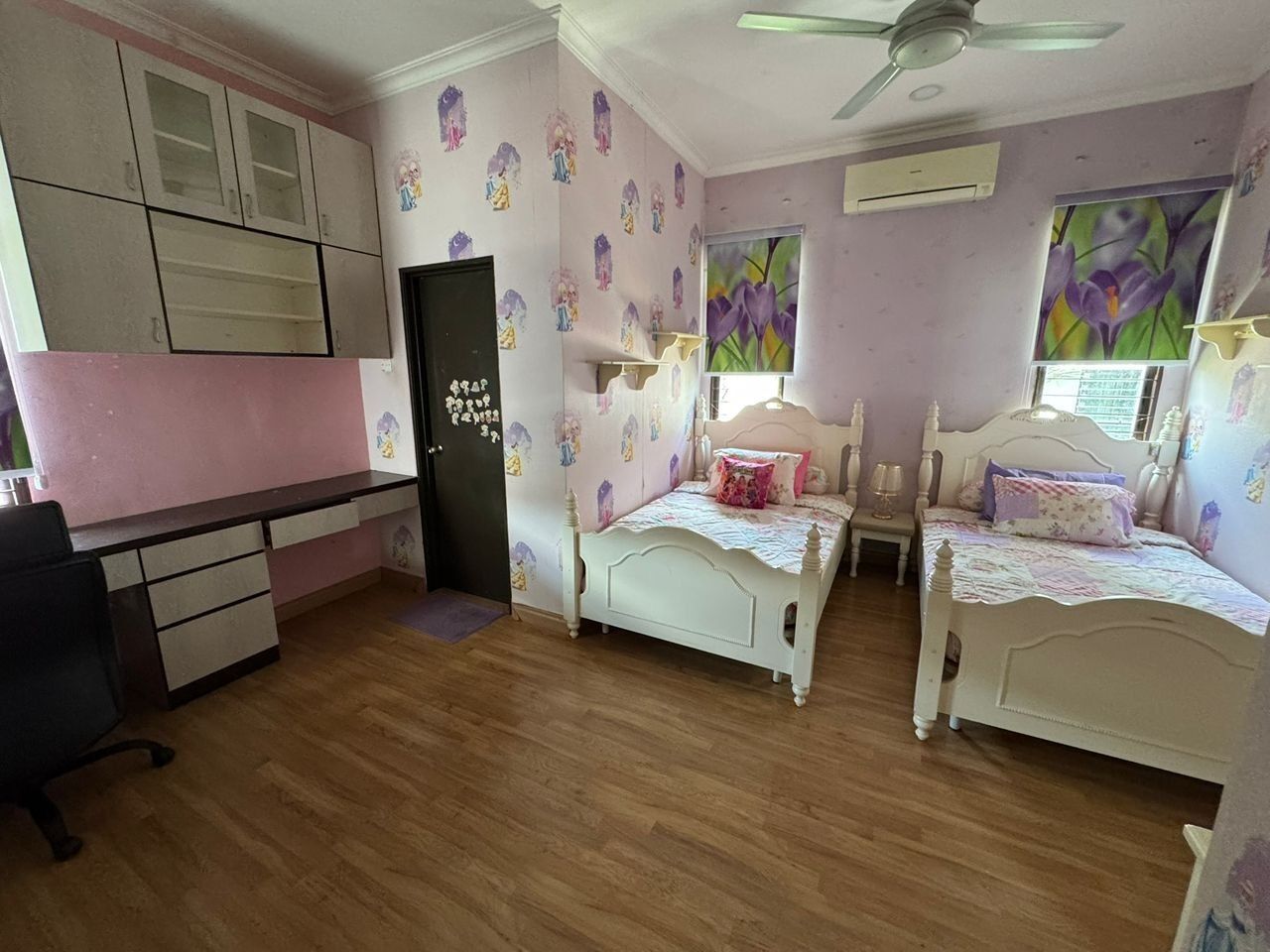 Une chambre avec deux lits simples, un bureau et une chaise.
