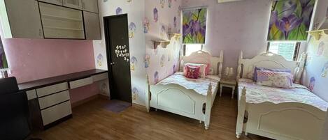 Un dormitorio con dos camas individuales, un escritorio y una silla.