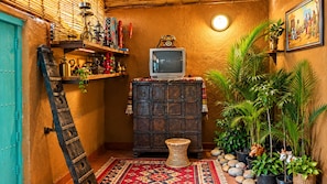 Una stanza rustica con un armadio in legno, una televisione e diversi oggetti decorativi.