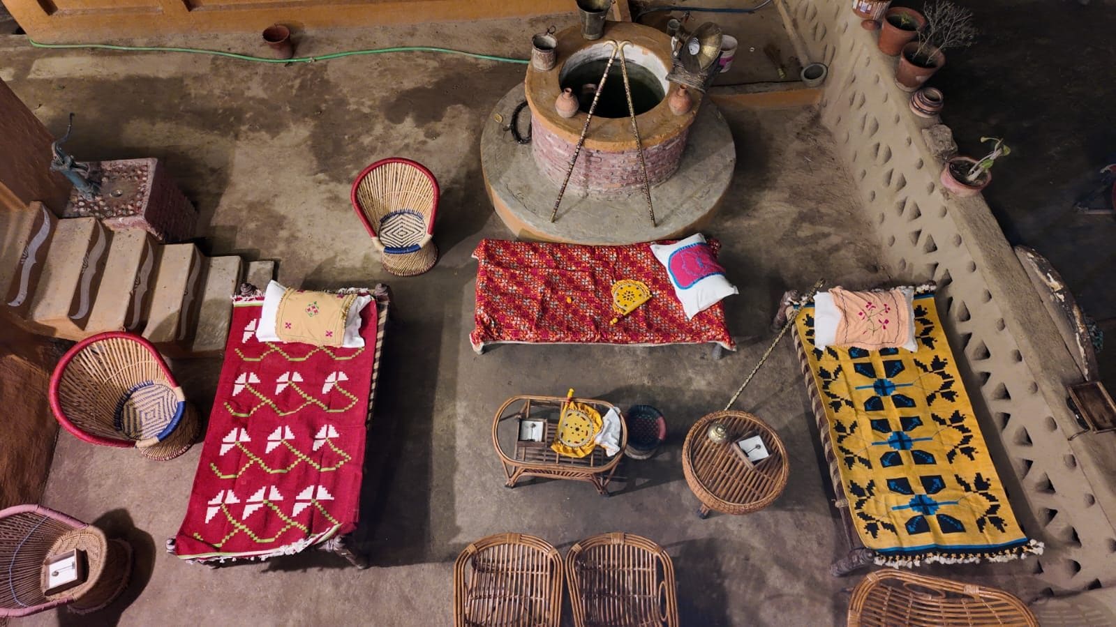 A traditional setting with a central fire pit, multiple seating areas, and a variety of woven baskets.