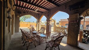 Un patio al aire libre con mobiliario de mimbre y vista a la ciudad.