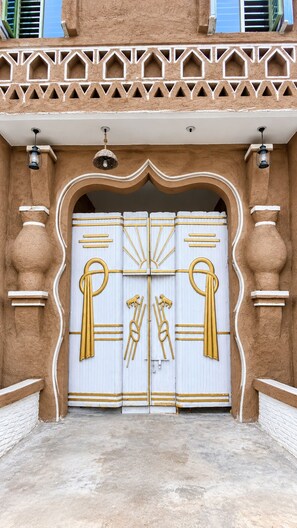 A large, ornate entrance with a decorative archway and two sets of double doors.