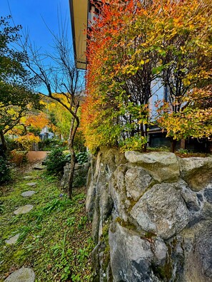 A stone wall with a garden path leading to a building.