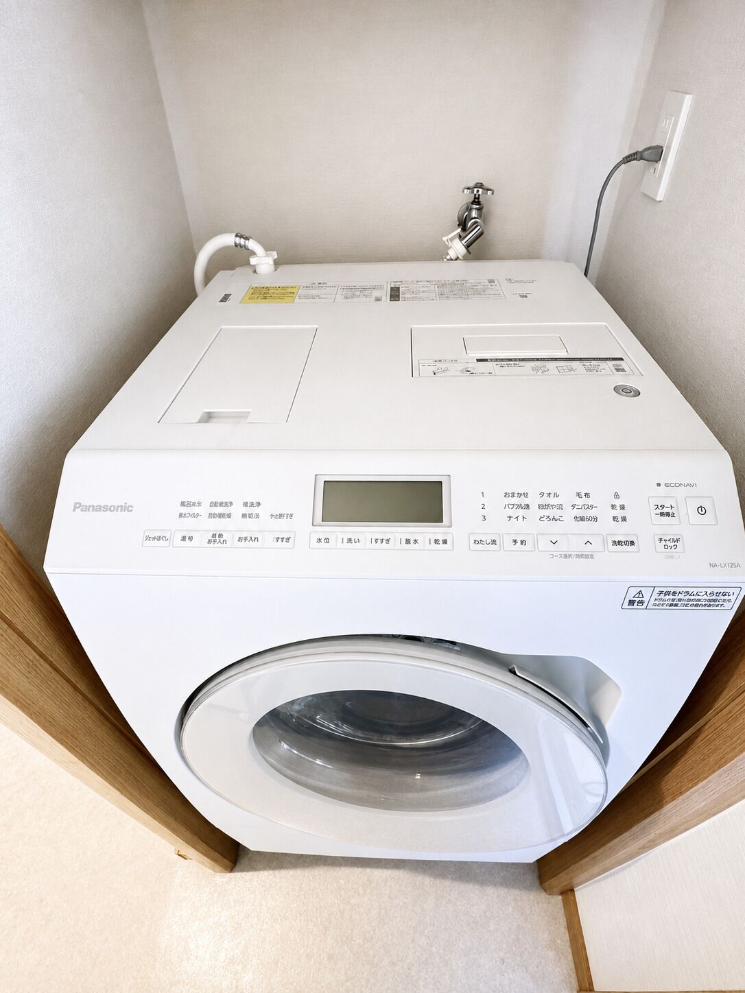 A white Panasonic washing machine with a control panel, a digital display, and a transparent door.