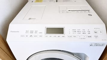 A white Panasonic washing machine with a control panel, a digital display, and a transparent door.