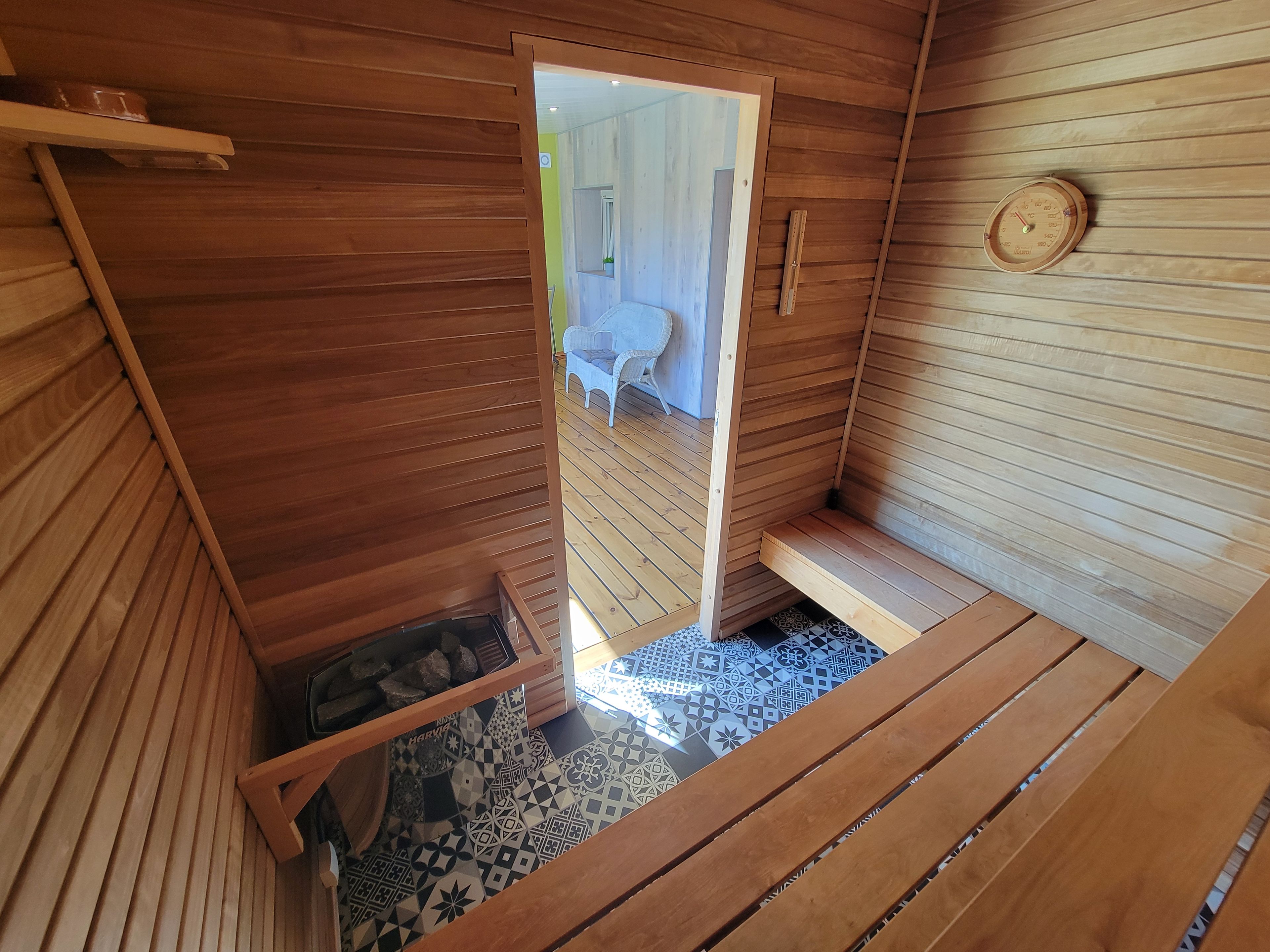 Un intérieur en bois agrémenté d’un miroir, d’une horloge et d’un sol à motifs.