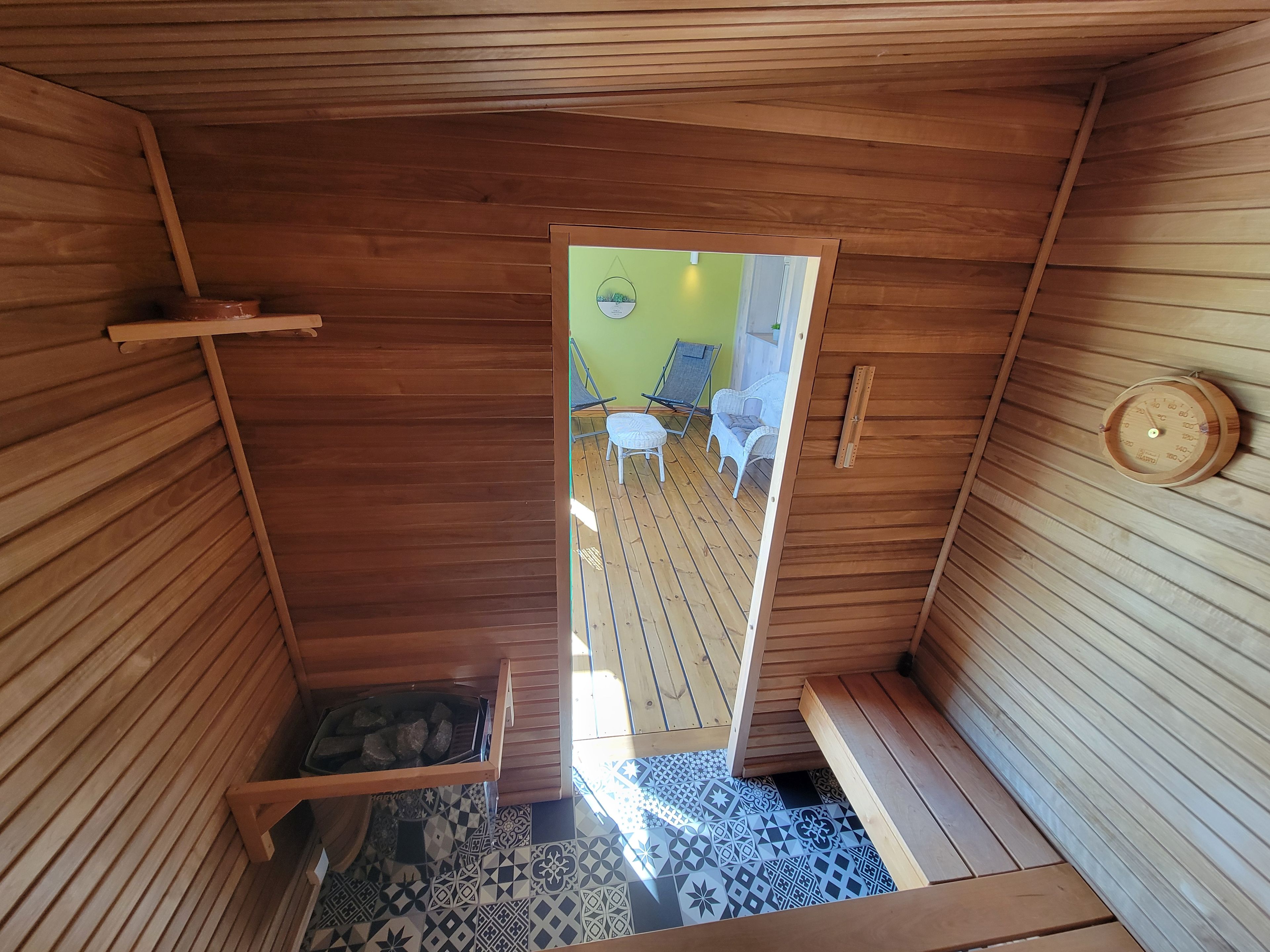 Un interior de madera con un banco, una mesa pequeña y un piso con diseño.