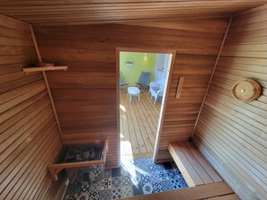 A wooden interior with a bench, a small table, and a patterned floor.