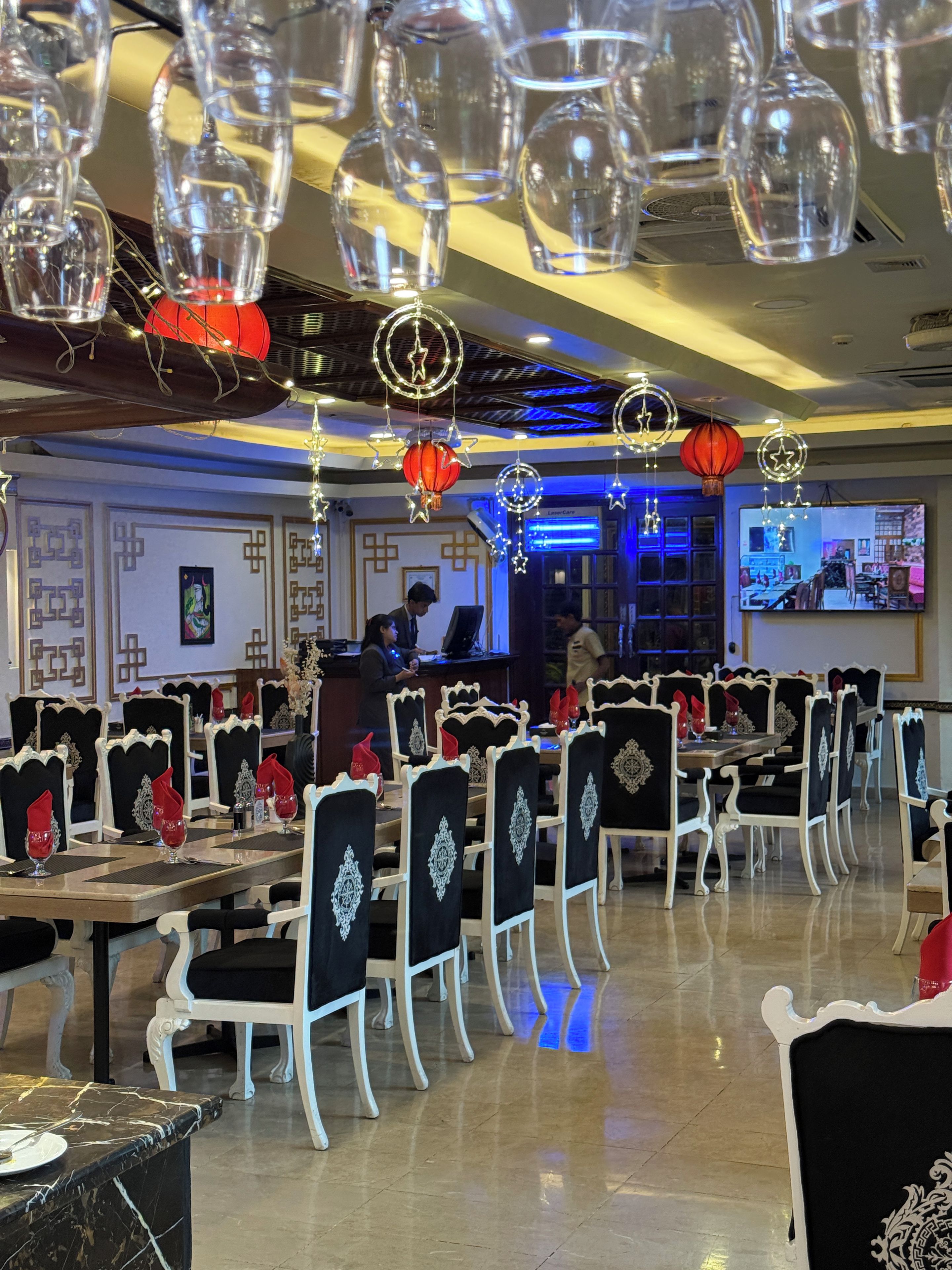 A restaurant with multiple dining tables, chairs, and a bar area.