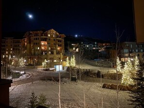 Um hotel com vários andares, iluminação externa e terreno coberto de neve.