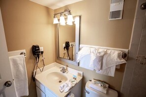 A bathroom with a sink, mirror, towel rack, and a hairdryer. - Atalaya Towers - 3 Bedroom (Murrells Inlet)