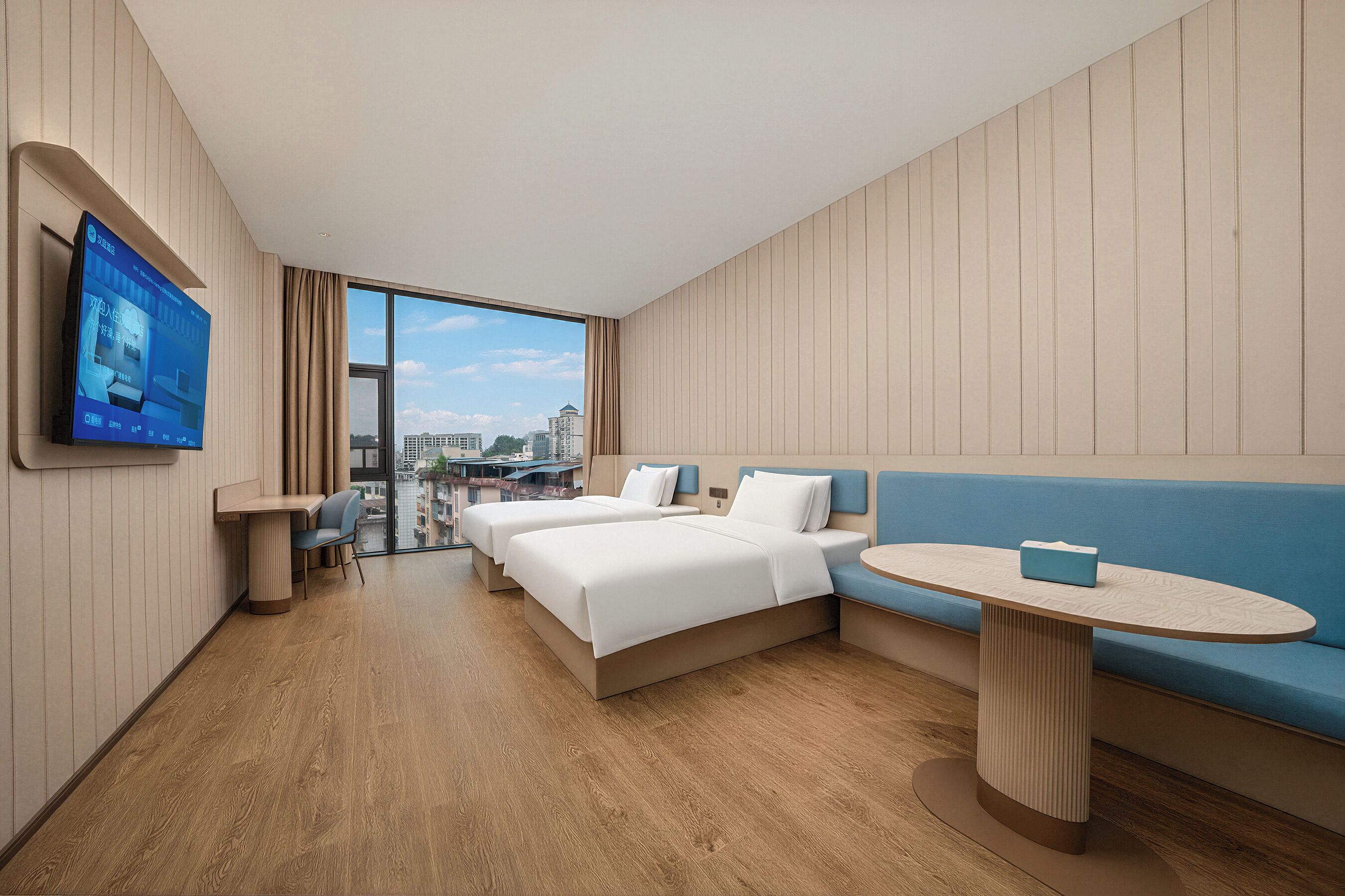 Une chambre d’hôtel avec un lit, un canapé, une petite table et un téléviseur fixé au mur.