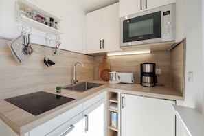 A modern kitchen with a built-in microwave, a coffee maker, and a toaster. - Kyra - Westerland (Westerland)