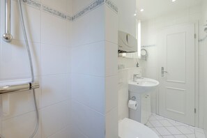 A bathroom with a shower, toilet, sink, and a mirror. - Kyra - Westerland (Westerland)