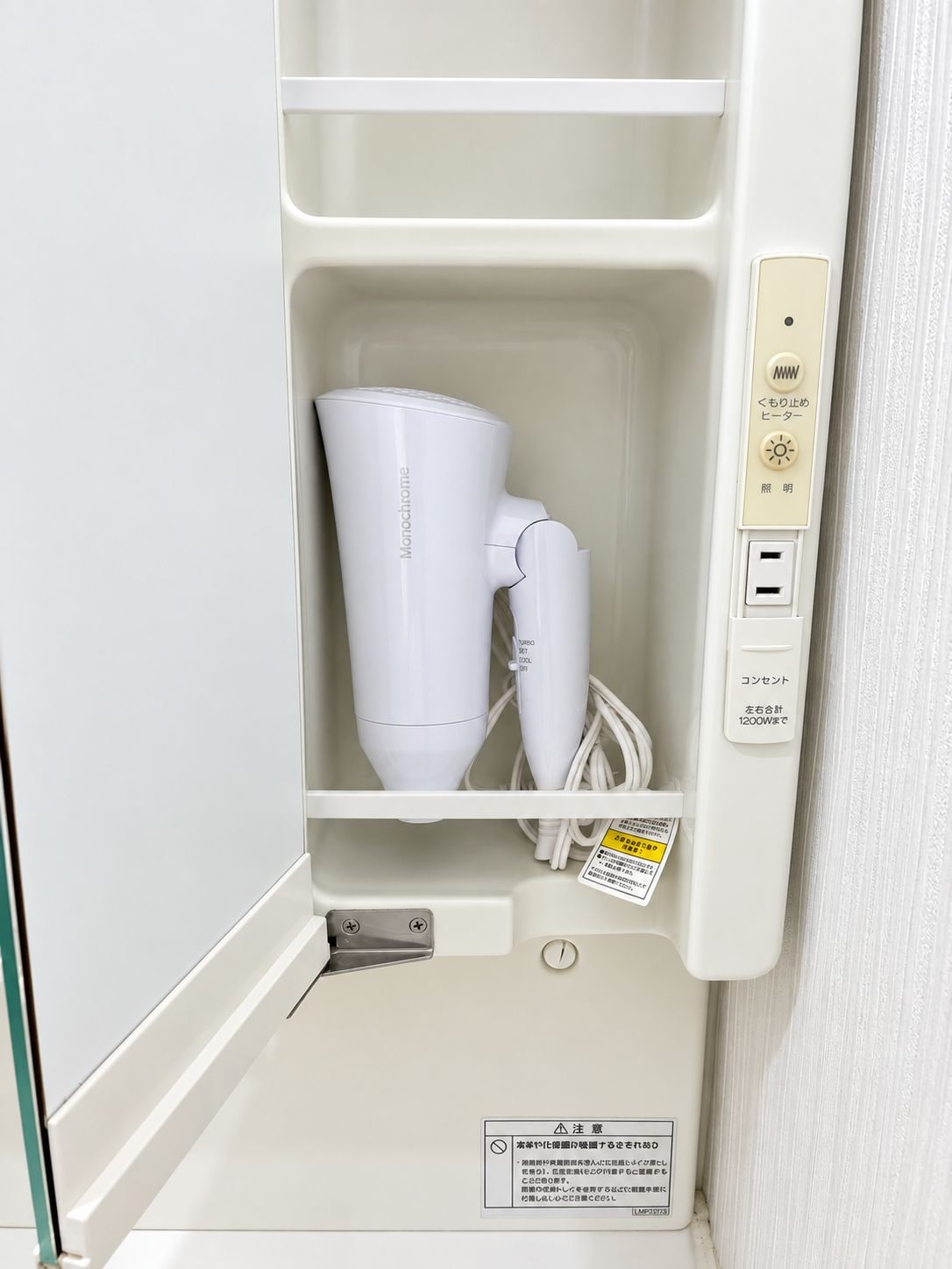 A white appliance with a control panel, a power cord, and a warning label.
