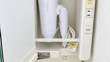 A white appliance with a control panel, a power cord, and a warning label.