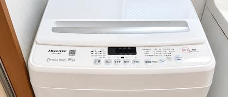 A compact, white, front-loading washing machine with a digital display, control panel, and a water inlet.
