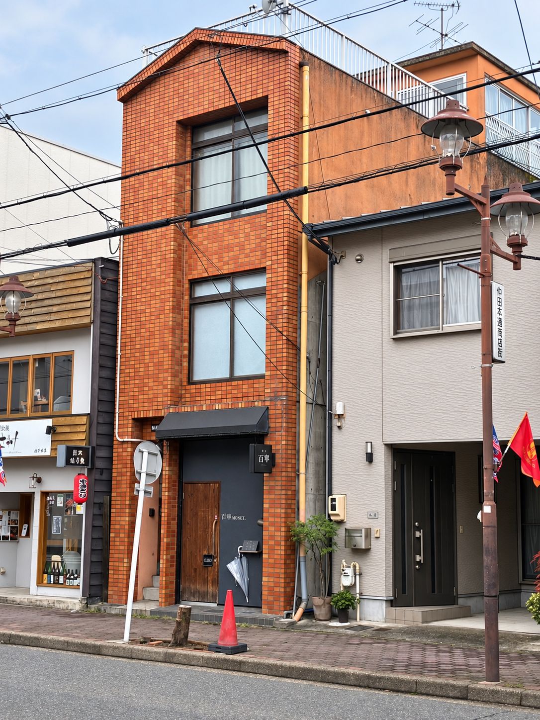 A two-story building with a brick facade and a black awning over the entrance.