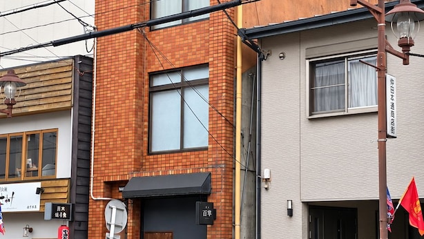 A two-story building with a brick facade and a black awning over the entrance. - The House Nagoya 5DK (Nakata, Chikusa-ku, Nagoya-shi)