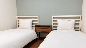 A twin room with two beds, a nightstand, and a wooden floor. - The House Nagoya 5DK (Nakata, Chikusa-ku, Nagoya-shi)