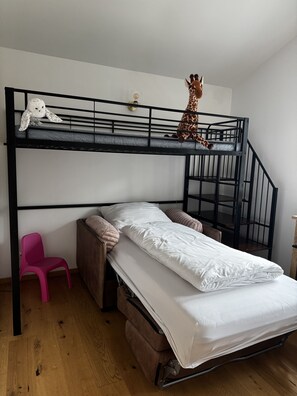 A bunk bed with a lower bunk, a pink chair, and a stuffed giraffe on the top bunk. - Watzmann Vacation Rental, 74 square meters (Schönau am Königssee)