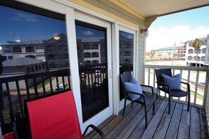 Eine Holzterrasse mit Sitzgelegenheiten im Freien und Blick auf ein mehrgeschossiges Gebäude.