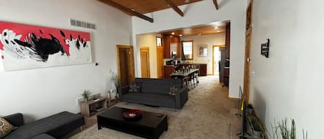 A living room with a sofa, coffee table, and artwork on the wall.