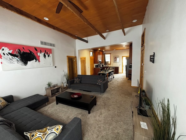A living room with a sofa, coffee table, and artwork on the wall.