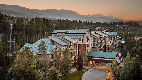 A multi-story hotel with a modern architectural design, featuring a central courtyard and multiple balconies.