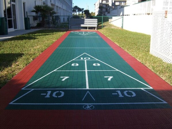 A shuffleboard court with numbers 10, 9, 8, 7, and 6 marked on it. - Beachfront 2BR Retreat | Balcony + Full Kitchen (Cocoa Beach)