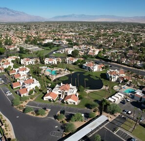 A residential area with houses, a swimming pool, and a bridge. - Relaxing 1BR Desert w/ Pool & Parking (Palm Desert)