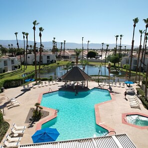 A resort with a central swimming pool, lounge chairs, and palm trees. - Relaxing 1BR Desert w/ Pool & Parking (Palm Desert)