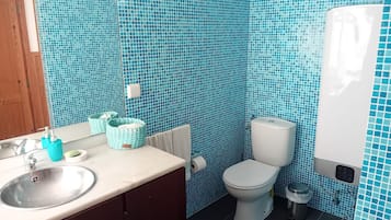 Un bagno con lavandino, wc e asciugamano ad aria.