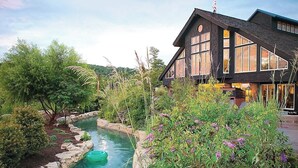 A house with a large window, a stone pathway, and a small water feature.