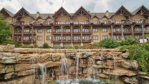 A multi-story hotel with a stone waterfall feature in front.