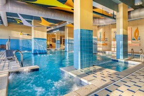 Una piscina interior con agua cristalina, paredes de azulejos y un diseño moderno.