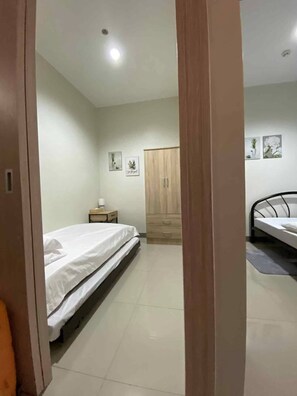 A bedroom with a bed, a wardrobe, a desk, and a nightstand. - Cosy Family staycation Casa De Nordeka Felix (Cainta)